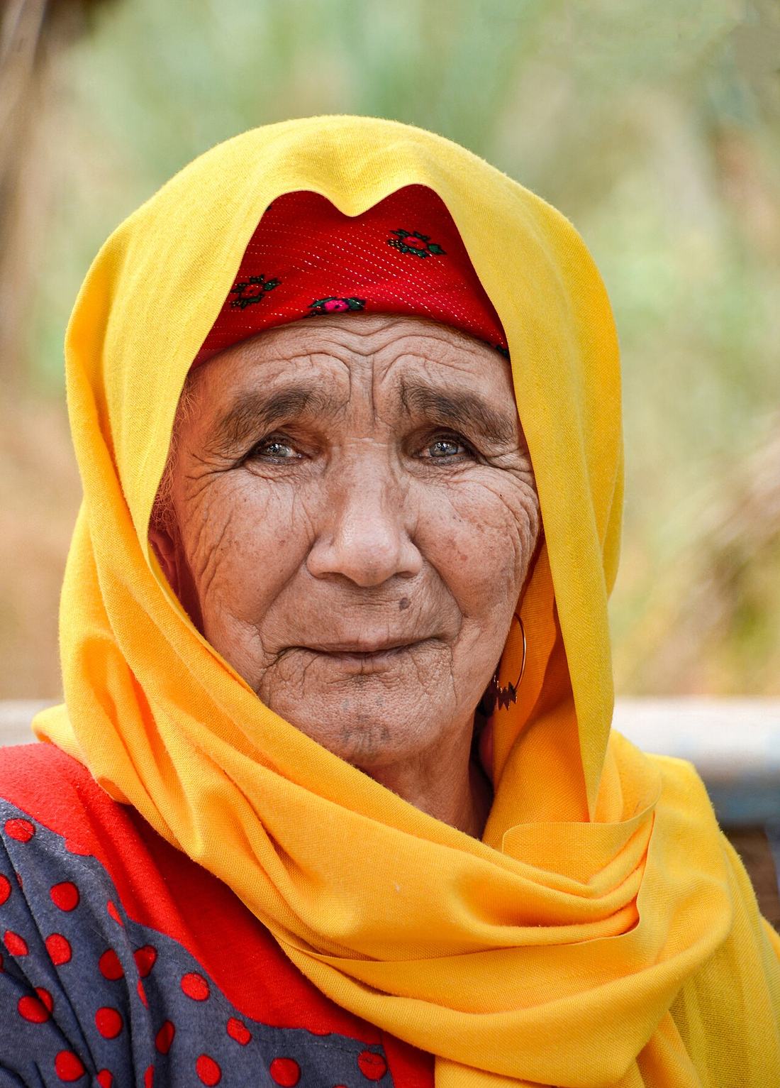 An older woman wearing a yellow scarf
