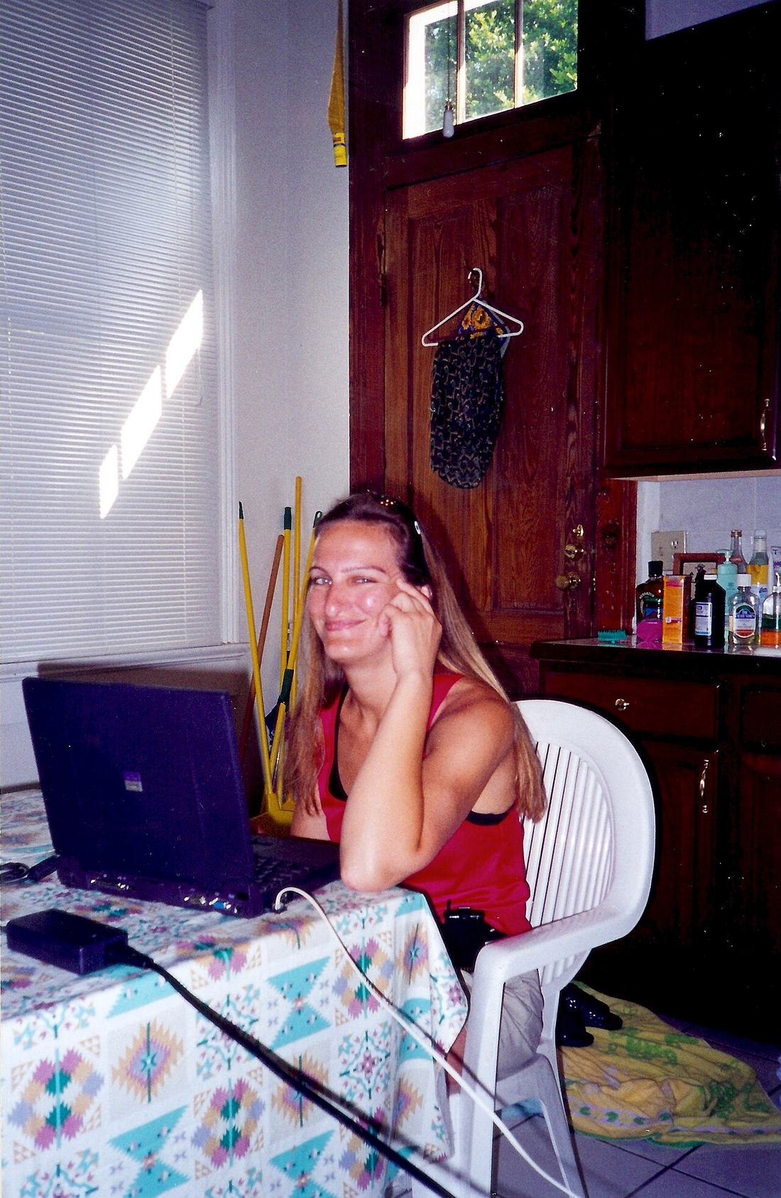 A person using a laptop at a kitchen table