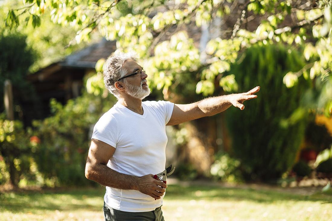 A senior man enjoying a sunny day in the garden